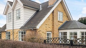 A two-story house with a brick facade and a white upper section. - 4 Star Holiday Home in Hals (Hals)