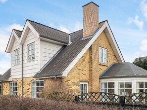 A two-story house with a brick facade and a white upper section. - 4 Star Holiday Home in Hals (Hals)