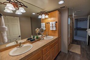Une salle de bain avec deux lavabos, un grand miroir et un meuble-lavabo en bois.