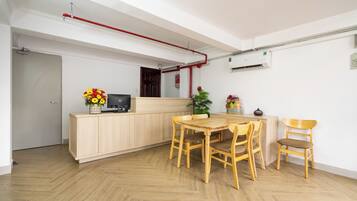 Une cuisine de taille réduite avec des meubles en bois, une table à manger avec des chaises, une plante en pot et un petit objet décoratif posé sur le comptoir.