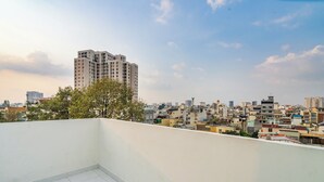 A rooftop terrace with a cityscape view, including high-rise buildings and a clear sky. - Chill Hill Hotel & Home (Ho Chi Minh City)