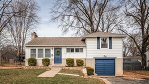 A single-story house with a front porch, a garage, and a well-maintained lawn. - Family friendly, Youth Sports tournaments, World Cup-Ready, Lenexa, 3BR Near KC (Lenexa)