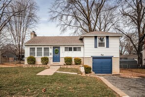 A single-story house with a front porch, a garage, and a well-maintained lawn. - Family friendly, Youth Sports tournaments, World Cup-Ready, Lenexa, 3BR Near KC (Lenexa)