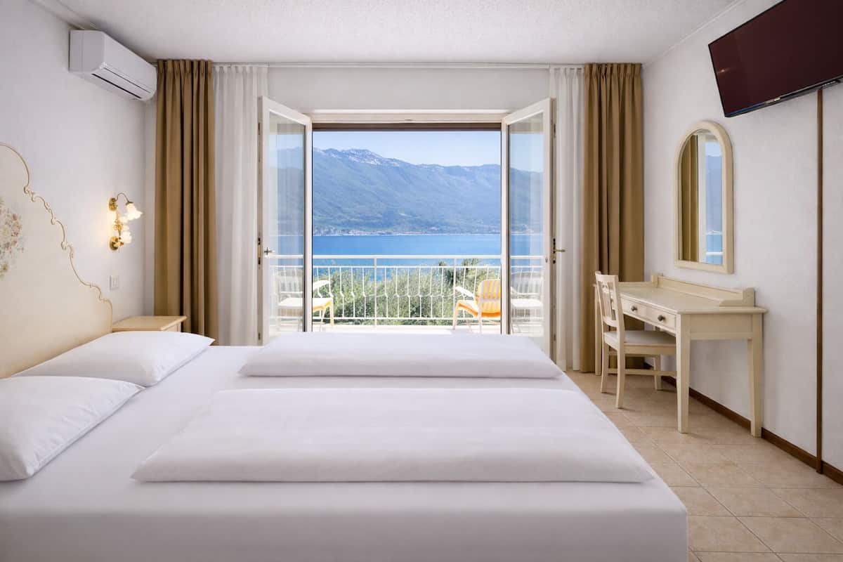 Una habitación de hotel con una cama grande, un escritorio, una silla y un televisor.