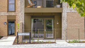 Kaksikerroksinen kerrostalo, jossa on parveke, kyltti, jossa lukee ”Mille Avenue 29–109”, ja portilla varustettu sisäänkäynti.