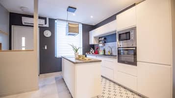 Een koelkast met diepvriezer, een microgolfoven, een oven, een kookplaat