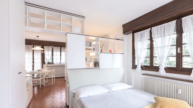 Ein Schlafzimmer mit einem Bett, einem Schreibtisch und einem Stuhl im angrenzenden Raum.