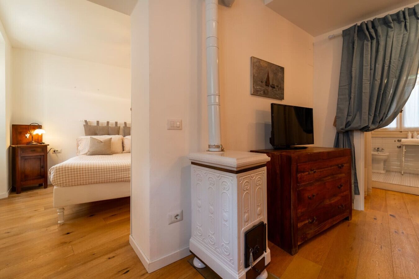 Une chambre à coucher comprenant un lit, une télévision, une commode et une salle de bain avec douche.