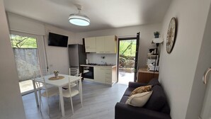 Un espace de vie compact comprenant un coin repas, une kitchenette et un canapé.