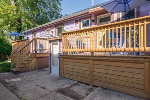 Una terraza de madera con barandilla de madera, una puerta y un letrero que dice Lake Effect Club.