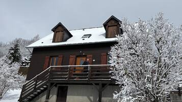 Une cabane en bois dotée d’un balcon et d’un escalier menant à l’entrée.