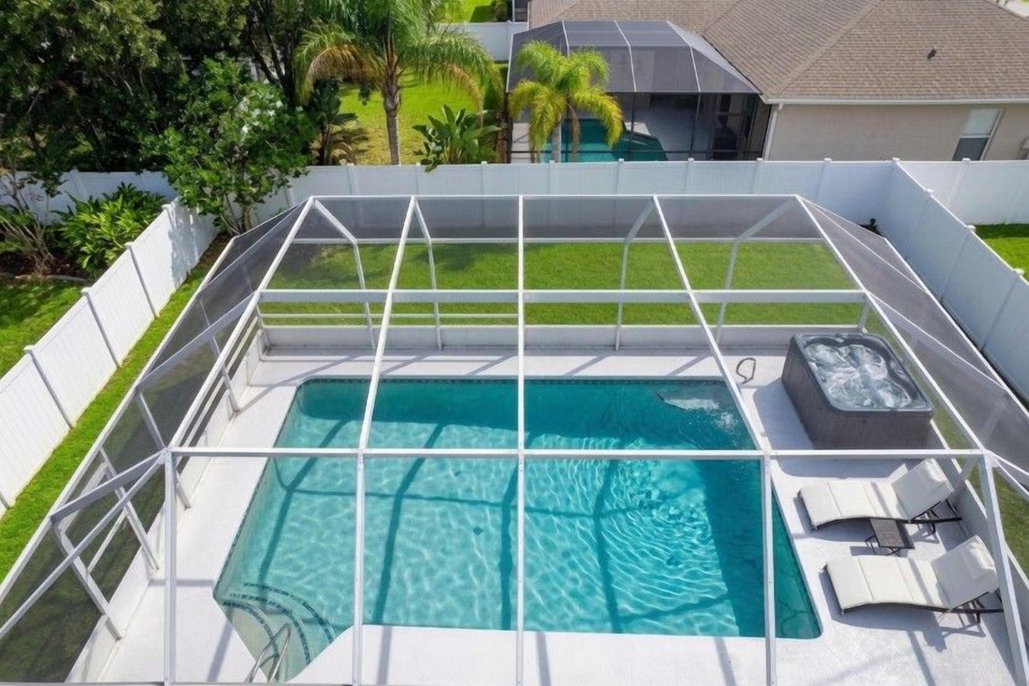 A rooftop pool with a hot tub and lounge chairs.