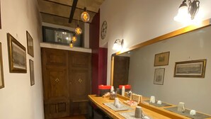 Una cocina con encimera de madera, taburetes de bar, bombillas colgantes y fotografías enmarcadas en la pared.