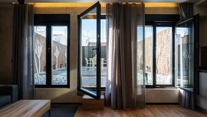 A modern room with large windows, a wooden bench, and a view of a backyard with a table and chairs. - Dobo Madrid MA24 (Madrid)