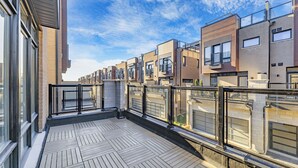 A modern apartment building with a wooden deck and glass railings. - Modern 4Bed Home in Richmond Hill /Rooftop Terrace & EV Charger (Richmond Hill)
