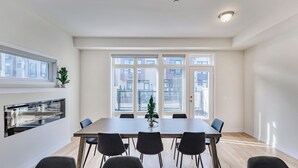 A modern kitchen with a built-in oven and a dining area with a large table and chairs. - Modern 4Bed Home in Richmond Hill /Rooftop Terrace & EV Charger (Richmond Hill)