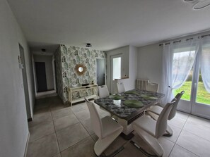 A dining area with a table, chairs, and a decorative wall. - Quiet house ideal for a family. (Saint-Aignan)