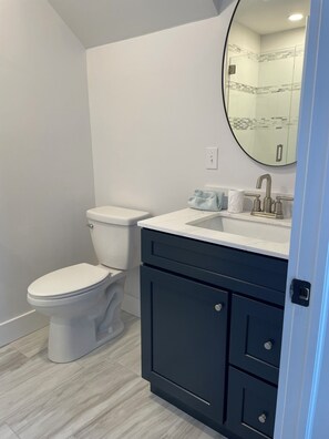 Un baño con inodoro, lavamanos y espejo.
