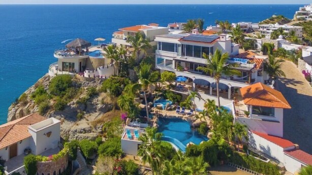 A coastal resort with multiple buildings, a central swimming pool, and views of the sea. - Pedregal Penthouse with Breathtaking Views (Cabo San Lucas)