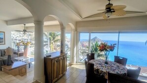 A spacious living area with a large window offering a view of the ocean and cityscape. - Pedregal Penthouse with Breathtaking Views (Cabo San Lucas)
