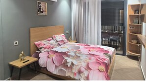 Een slaapkamer met een bed, nachtkastje en een kledingkast.