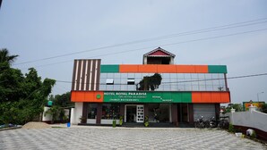 Um hotel chamado 'Hotel Royal Paradise', com design moderno, apresentando uma entrada imponente e uma varanda.