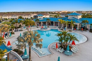 A resort with a large pool, sun loungers, and palm trees. - 5BR Pool Home at Windsor Island Near Disney (Davenport)