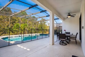 A covered outdoor area with a pool, seating, and a ceiling fan. - 6BR Family Home w/ Pool Near Disney (Kissimmee)