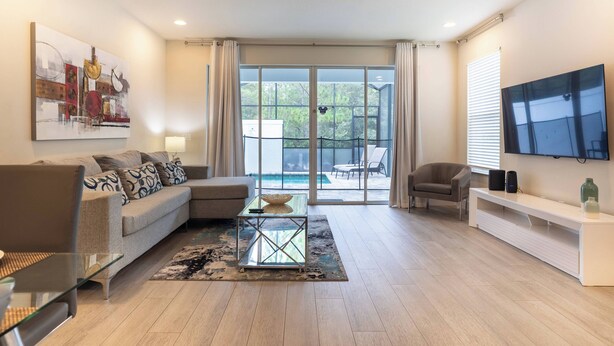 Un salon moderne avec un canapé, une table basse et un téléviseur.