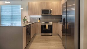 Une cuisine moderne avec des meubles en bois, des appareils en acier inoxydable et un îlot central.