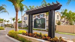 A sign for West Lucaya Village Resort with a pergola structure. - Home in West Lucaya | 4BR Near Disney (Kissimmee)