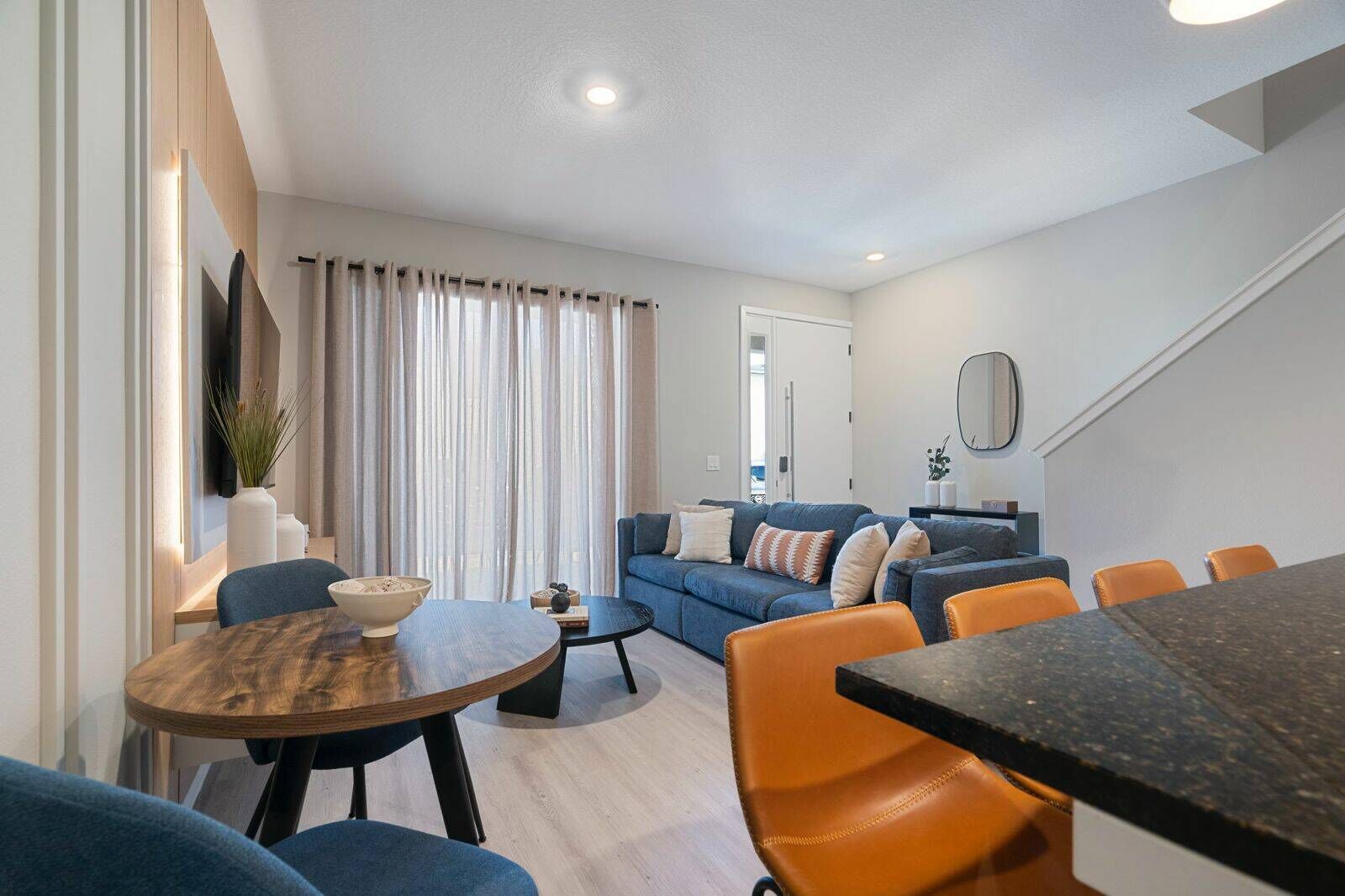 A modern living room with a sofa, coffee table, and dining area.