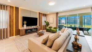 Ein modernes Wohnzimmer mit Flachbildfernseher, einer Couch, einem Couchtisch und einem Essbereich mit Stühlen und Tisch.