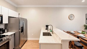 A modern kitchen with a built-in refrigerator, stove, and sink. - Renovated 3BR Home | Mickey Room | Near Disney (Kissimmee)
