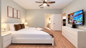 A bedroom with a bed, bedside tables, a television, and a ceiling fan. - Renovated 3BR Home | Mickey Room | Near Disney (Kissimmee)
