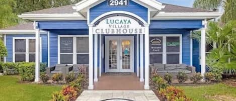 Un edificio azul con el número 2941 y el nombre 'Lucaya Village Clubhouse' en su fachada.
