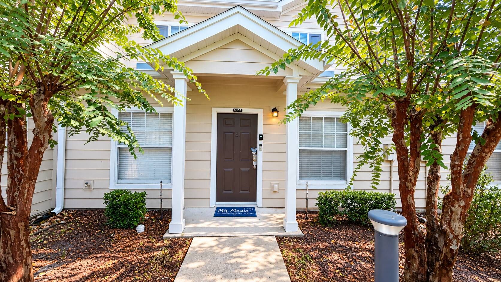 A residential building with a front door, a mailbox, and a small porch area.