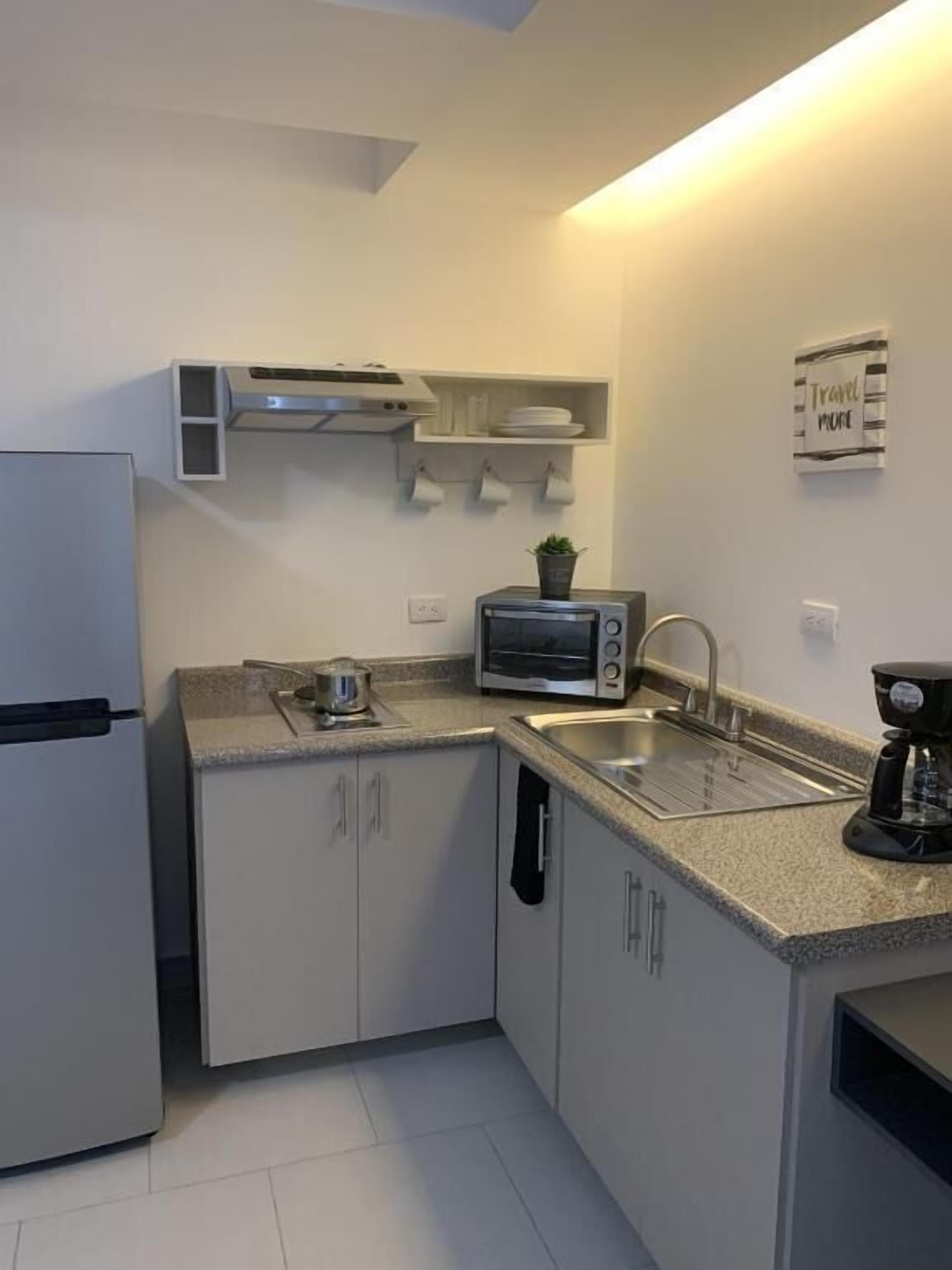 A compact kitchen with a built-in oven, a microwave, and a coffee maker.