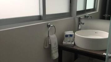 A bathroom with a white sink, a towel rack, and a mirror above the sink.