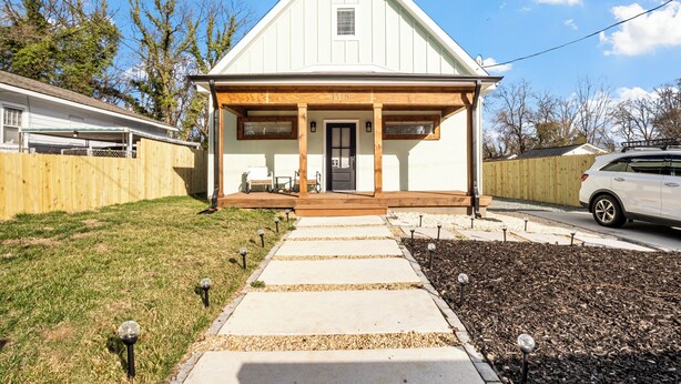 A single-story house with a front porch, a visible door, and a small window.