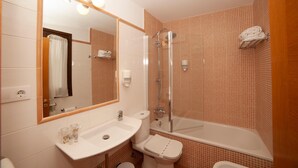 Een badkamer met een wastafel, toilet en bad.
