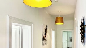 A hallway with a wooden floor, white doors, and a pendant light fixture. - Velbert - Apartament for 8P (Velbert)