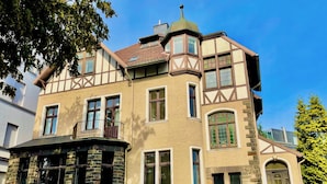 A traditional half-timbered house with a stone facade, multiple windows, and a small balcony. - Velbert - Apartament for 8P (Velbert)