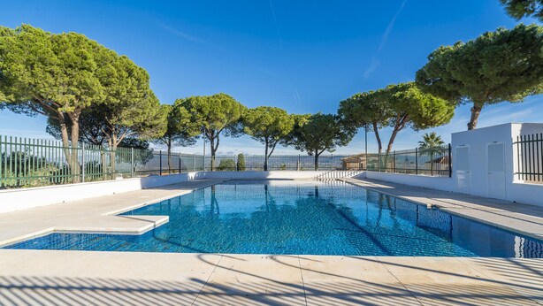 A rectangular swimming pool with clear blue water, surrounded by a white tiled deck and a metal fence. - Cubo's Cortijos del Sol Los Jazmines House / community pool / terrace / free wifi (Alhaurin de la Torre)