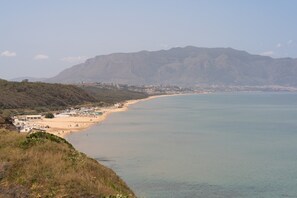 A coastal landscape with a beach, buildings, and mountains in the background. - Azzurra Apartments Trinacria with Sea View, Wi-Fi, and Air Conditioning (Balestrate)