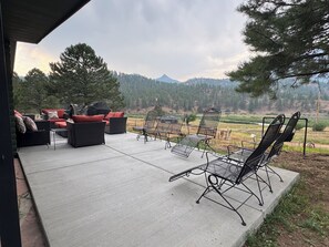 An outdoor patio with seating and a view of a mountainous landscape.