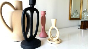 A white table with four decorative vases of varying shapes and sizes.
