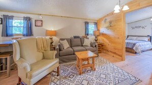 Une pièce confortable avec un canapé, une table en bois, un lit et un bureau.