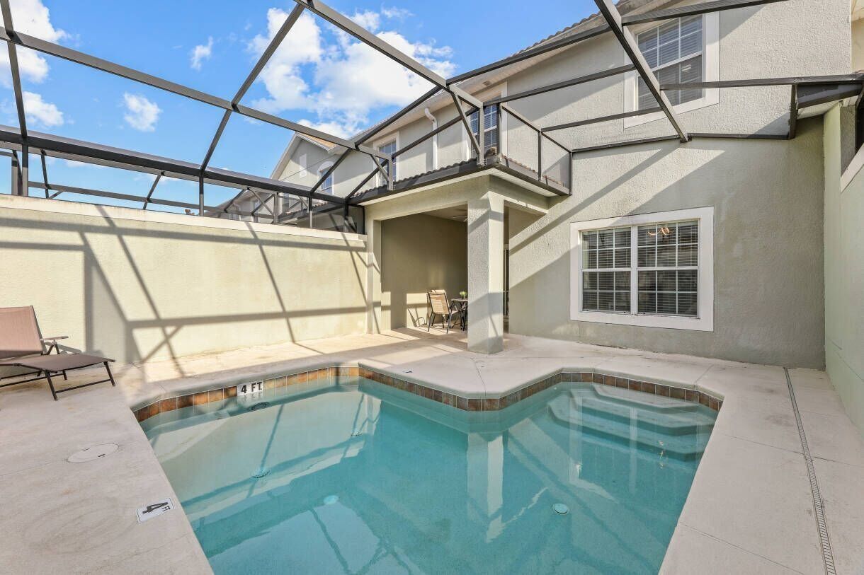 Una piscina con tetto in vetro, un patio coperto e vista sul cielo.
