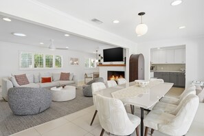A modern living room with a fireplace, a dining area, and a kitchen. - "La Veranda" a Movie Colony Palm Springs Resort Pool and View Home, #069334 (Palm Springs)